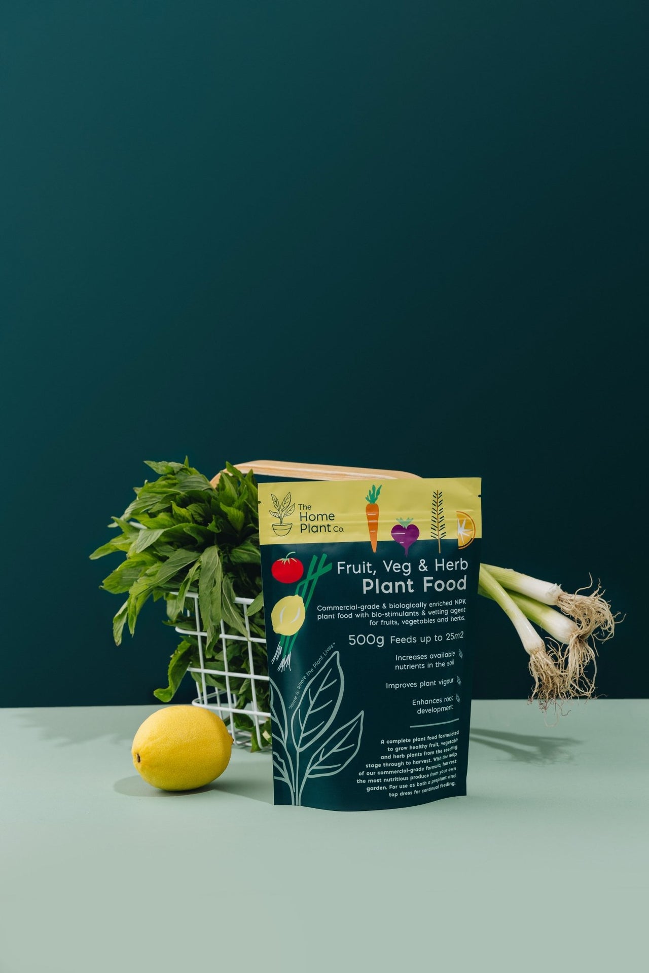 Fruit, Veg & Herb fertiliser granules standing next to a basket of fresh vegetables 